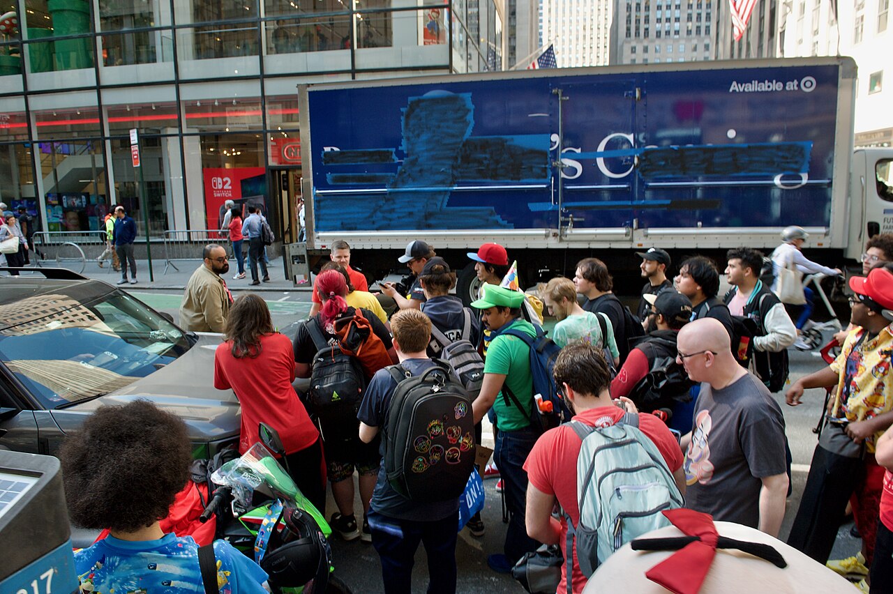 The launch event for the Nintendo Switch 2 at the Nintendo New York City store. A Nintendo staffer coordinates the migration from the other side of the street to the sidewalk adjacent to the Nintendo 